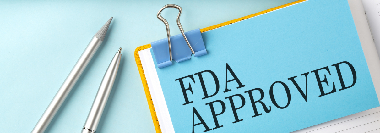 FDA APPROVED text on sticker on blue background with pen and keyboard