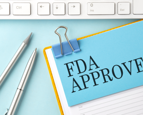 FDA APPROVED text on sticker on blue background with pen and keyboard